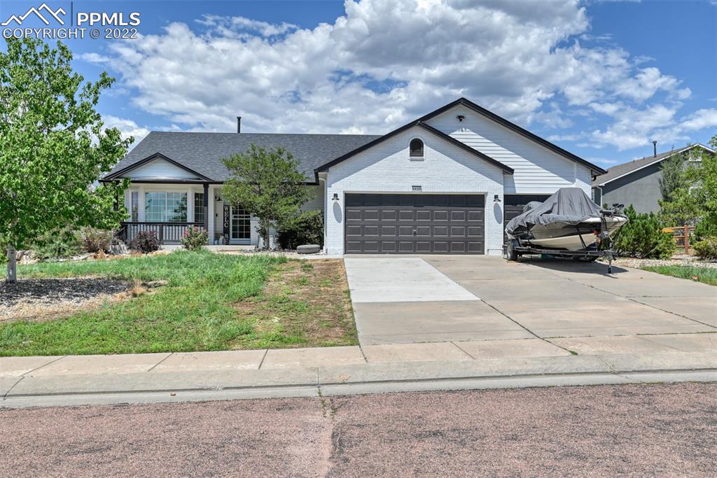 8820 Oakmont Road Peyton, CO 80831 - Photo 2 of 50 a front view of a house with a yard and garage