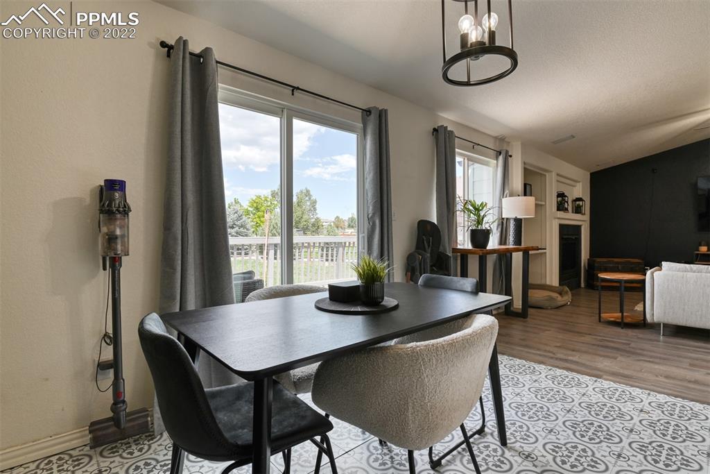 8820 Oakmont Road Peyton, CO 80831 - Photo 28 of 50 a dining room with furniture a chandelier and wooden floor