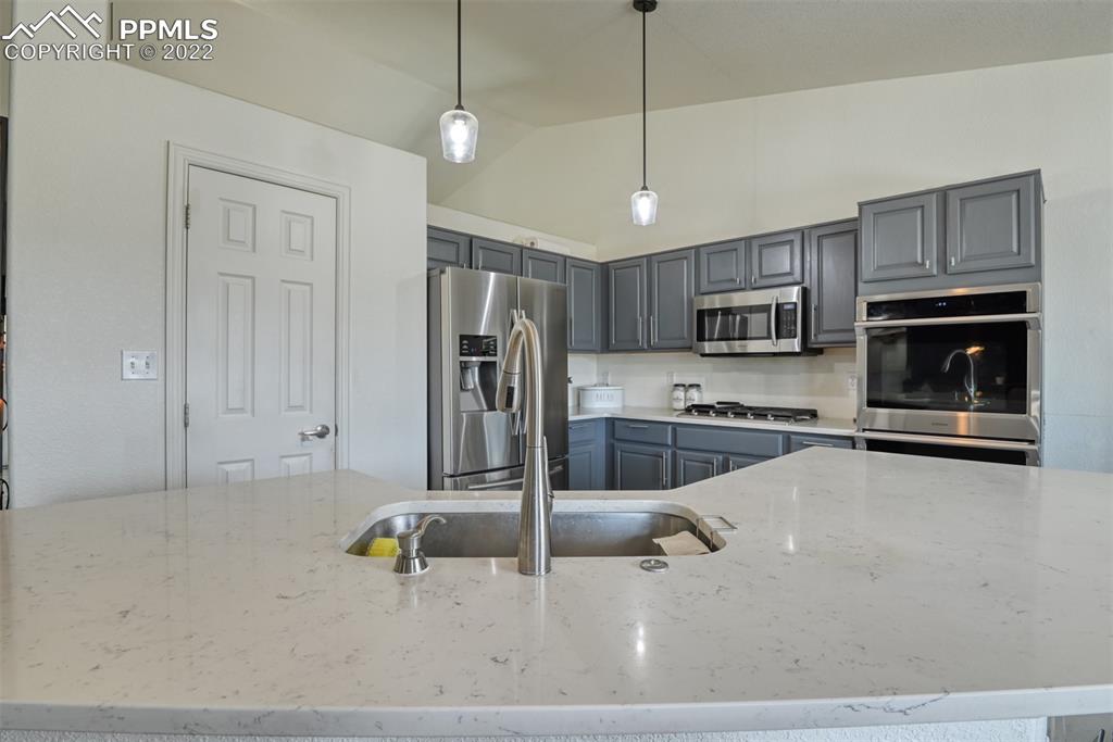 8820 Oakmont Road Peyton, CO 80831 - Photo 31 of 50 a kitchen with stainless steel appliances granite countertop a stove a sink and a refrigerator