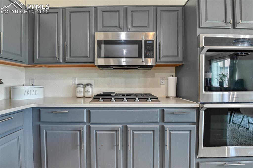 8820 Oakmont Road Peyton, CO 80831 - Photo 35 of 50 a kitchen with granite countertop a stove top oven microwave and cabinets
