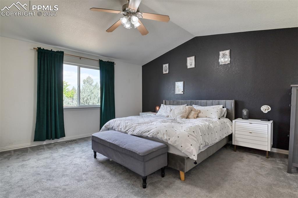 8820 Oakmont Road Peyton, CO 80831 - Photo 36 of 50 a spacious bedroom with a bed and a chandelier