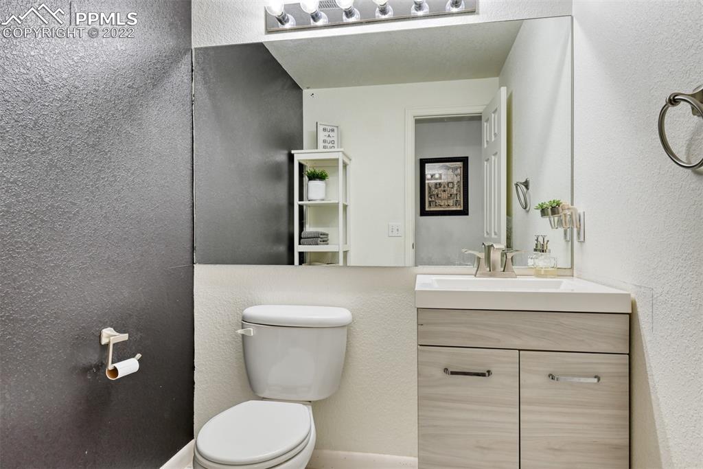 8820 Oakmont Road Peyton, CO 80831 - Photo 49 of 50 a bathroom with a toilet a sink a mirror and vanity