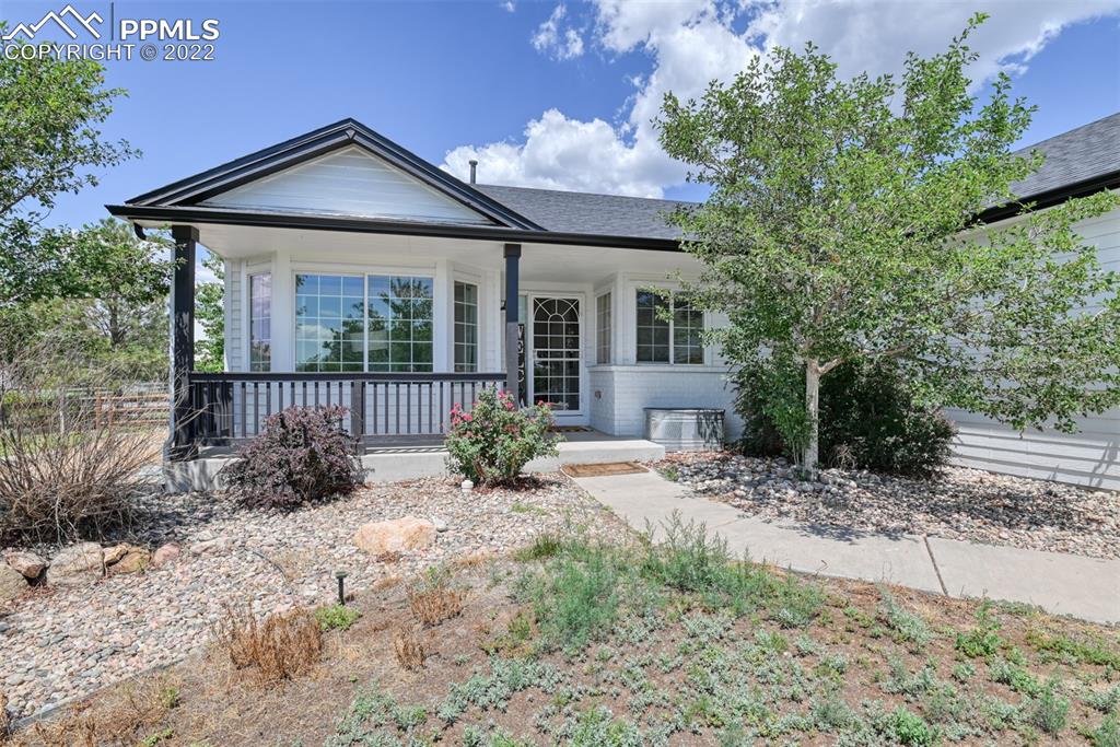 8820 Oakmont Road Peyton, CO 80831 - Photo 5 of 50 a front view of a house with a garden and plants