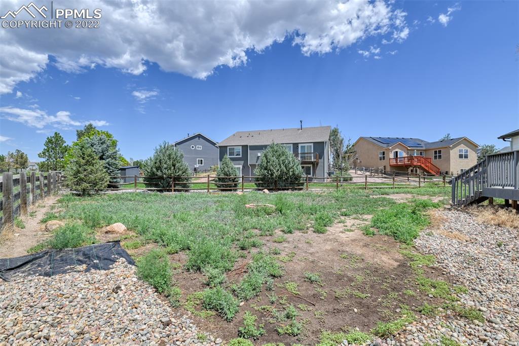 8820 Oakmont Road Peyton, CO 80831 - Photo 9 of 50 a view of a house with a big yard and large trees