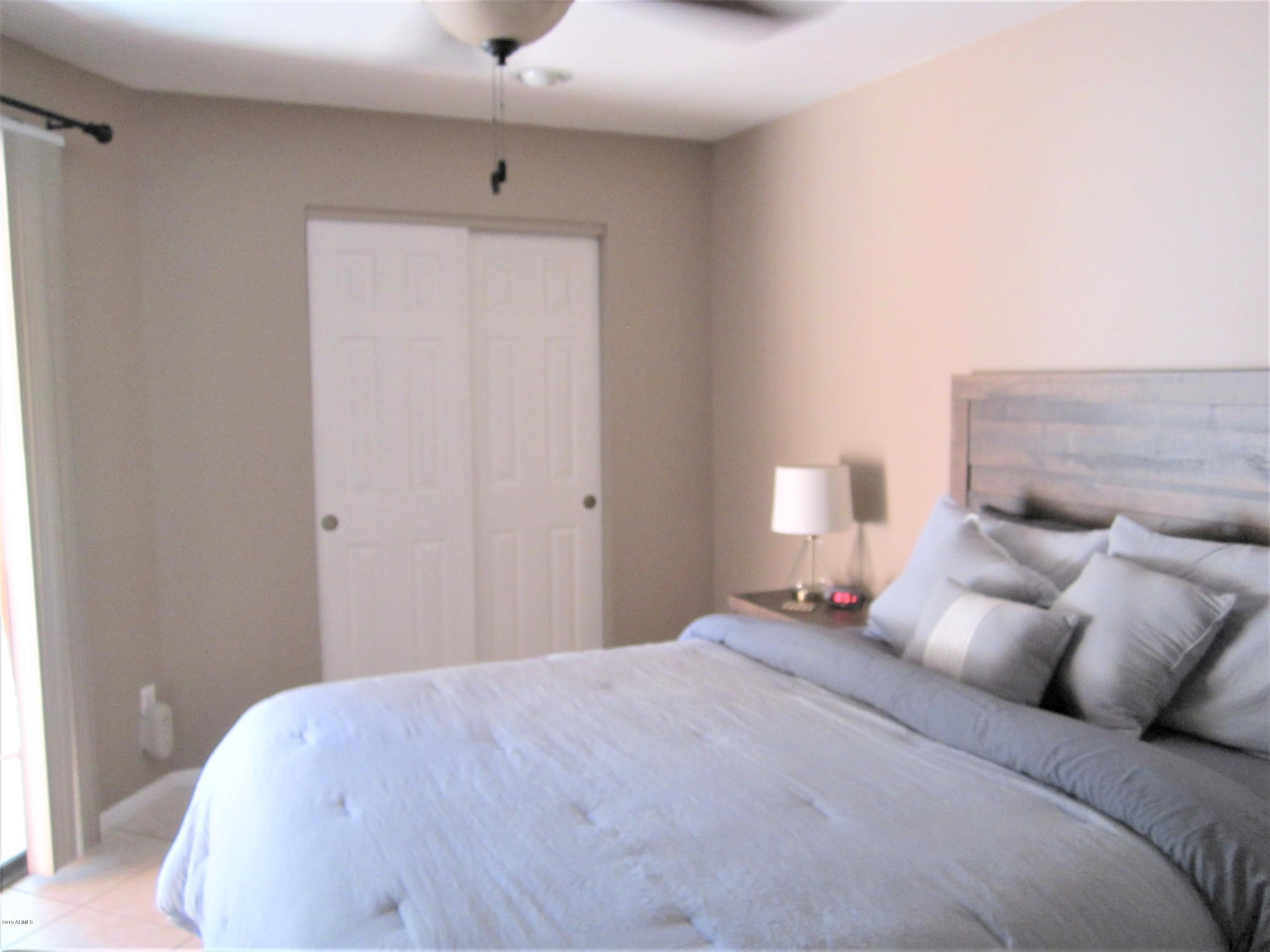 4303 East Cactus Road, Unit 116 Phoenix, AZ 85032 - Photo 11 of 35 a bedroom with a bed and a lamp