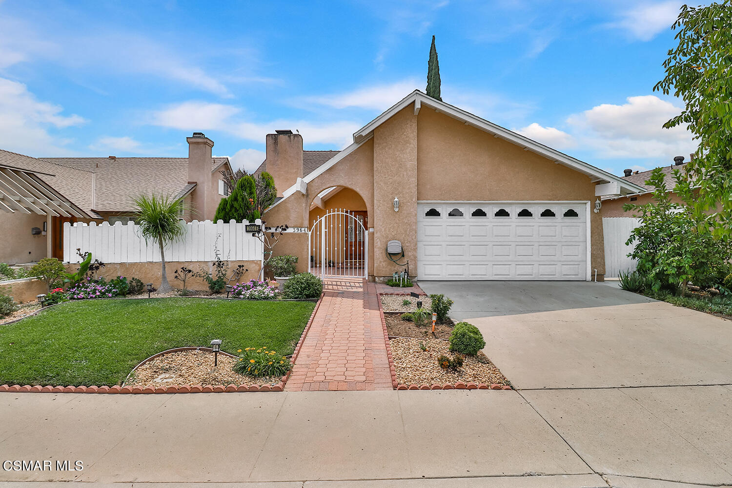 a front view of a house with a garden and plants