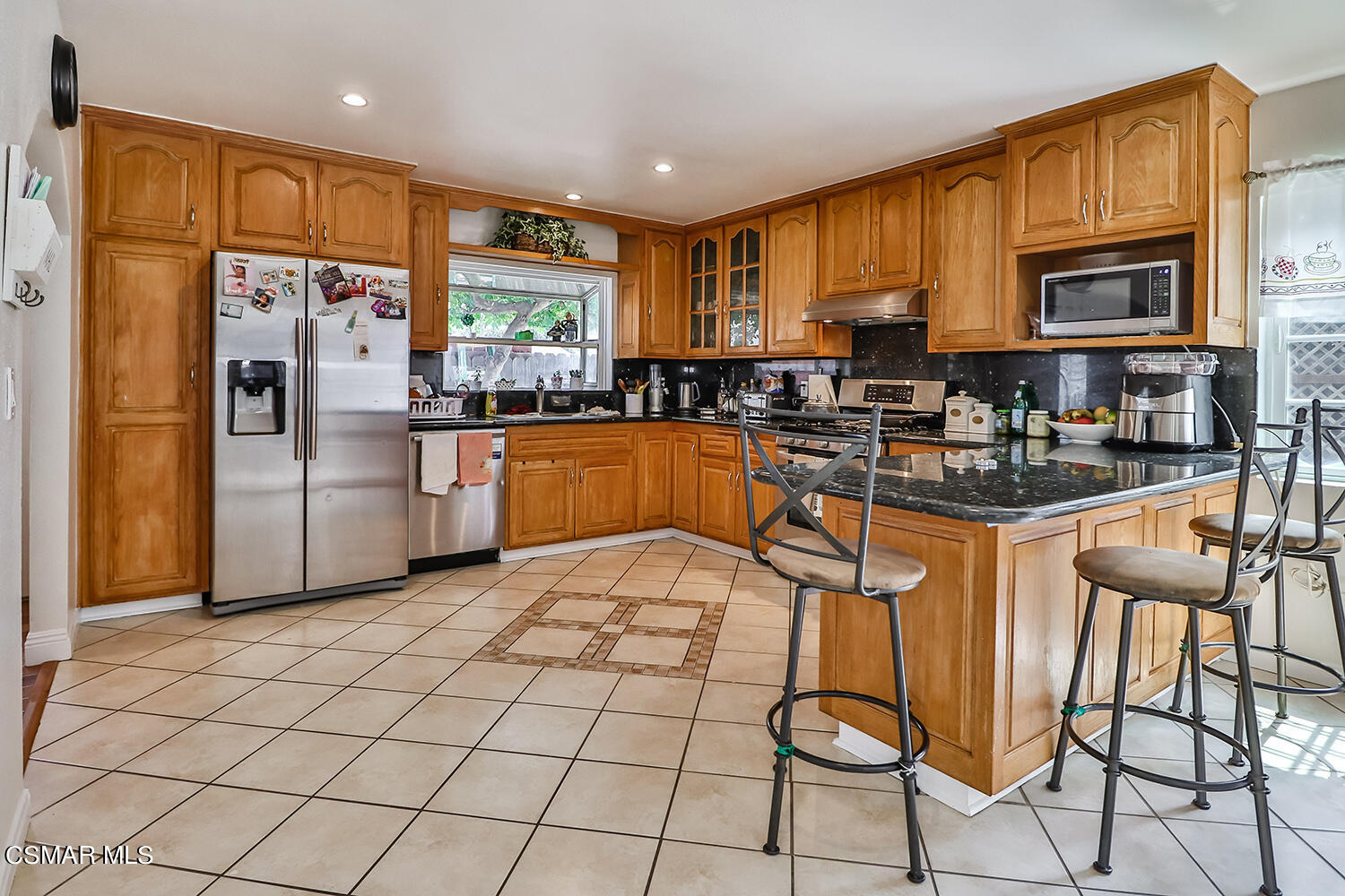 3964 Celia Court Simi Valley, CA 93063 - Photo 12 of 38 a kitchen with stainless steel appliances granite countertop a refrigerator a stove a sink a dining table and chairs with wooden floor