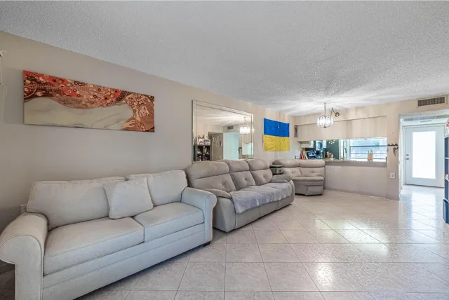 a living room with furniture and kitchen view