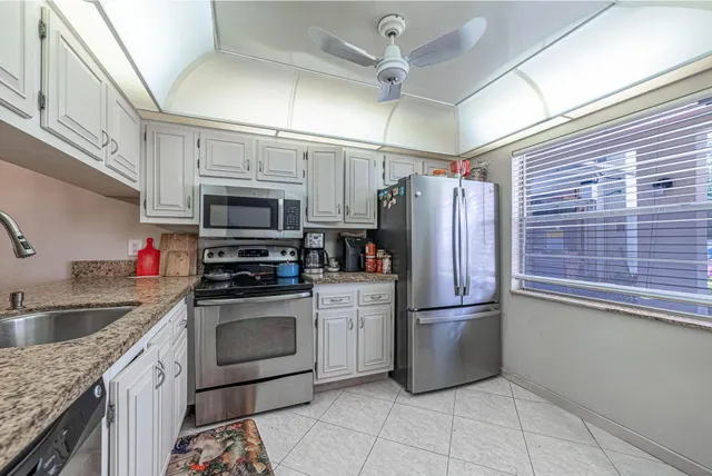 a kitchen with stainless steel appliances granite countertop a refrigerator and a sink