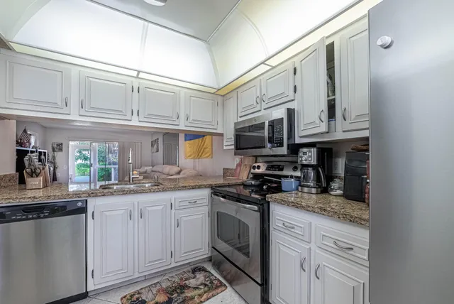 a kitchen with stainless steel appliances granite countertop a sink and cabinets
