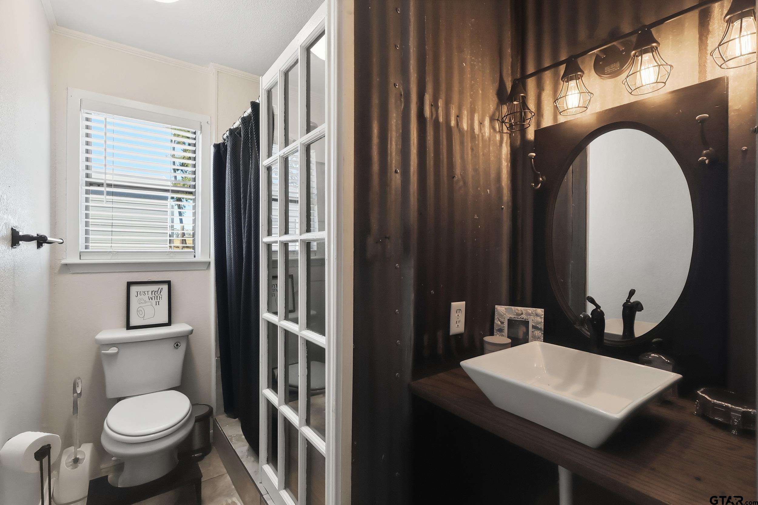 1775 County Road 1342 Pittsburg, TX 75686 - Photo 13 of 35 a bathroom with a toilet a sink and a mirror