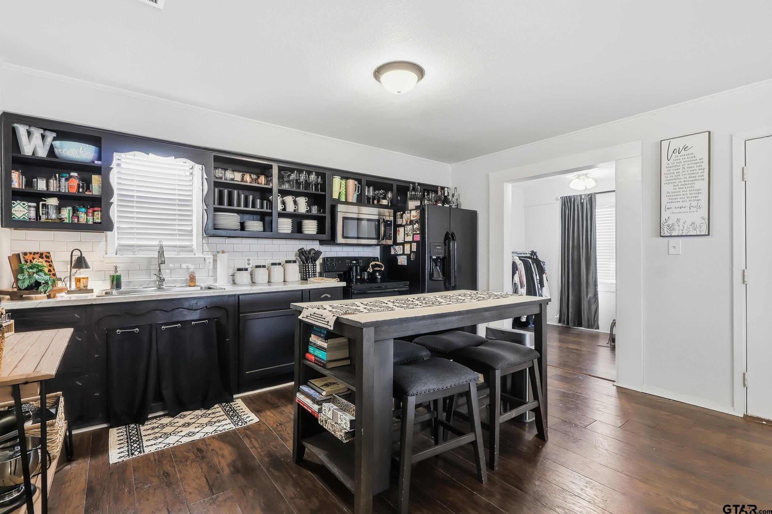 1775 County Road 1342 Pittsburg, TX 75686 - Photo 10 of 35 a kitchen with stainless steel appliances granite countertop a table chairs sink and wooden floor