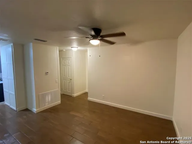 an empty room with a empty space and a ceiling fan
