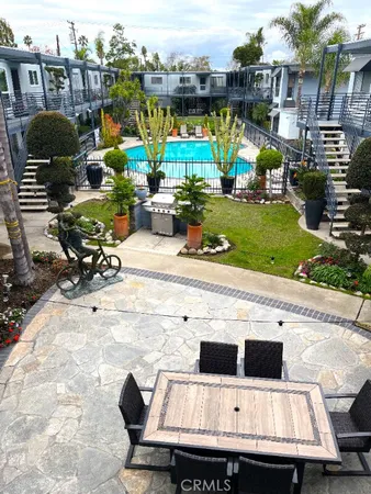 a view of a chairs and table in the back yard of a building