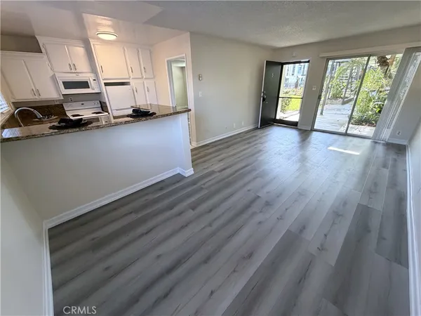 a view of a kitchen with wooden floor and electronic appliances