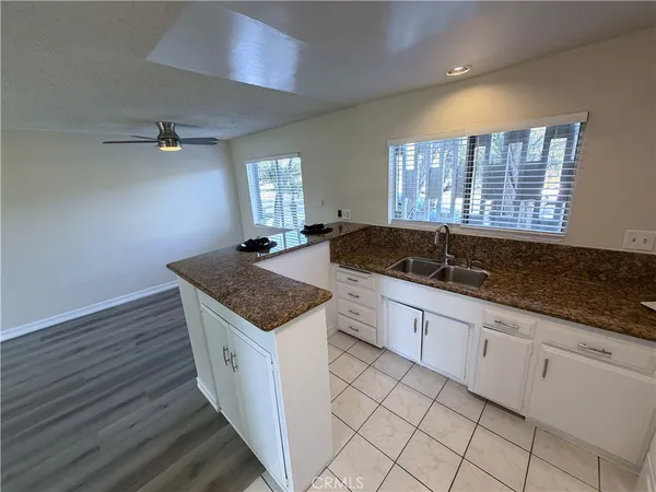 a kitchen with granite countertop a sink and a cabinets