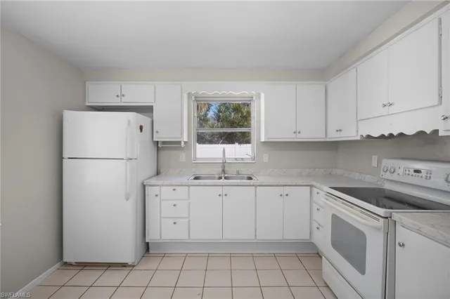 a kitchen with white cabinets and white appliances