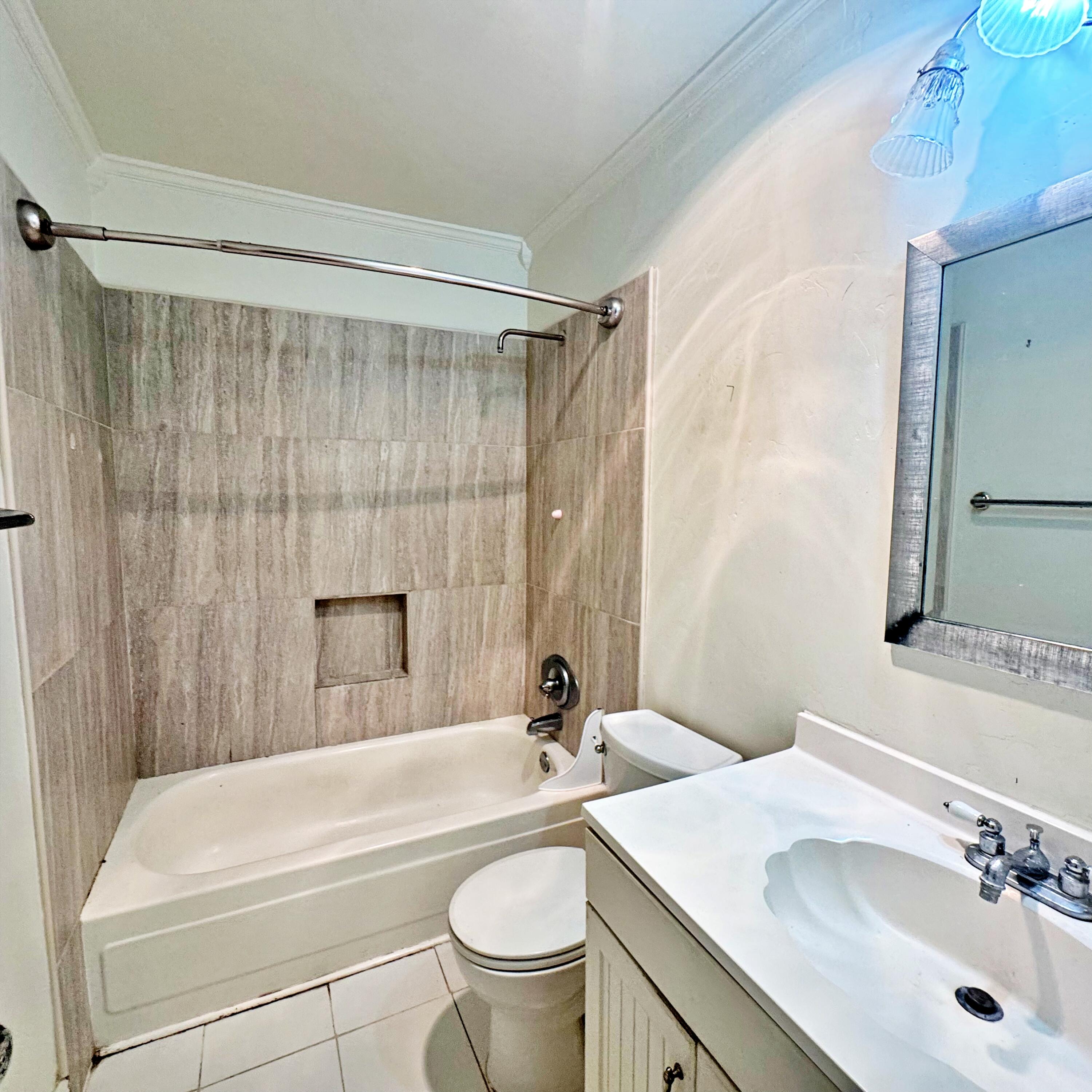 210 Pelham Road, Unit 215B Fort Walton Beach, FL 32547 - Photo 19 of 23 a bathroom with a sink a toilet a mirror a bathtub and shower