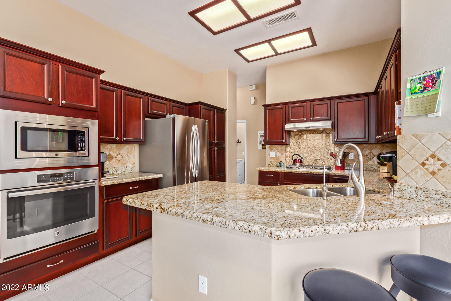 4515 East Jaeger Road Phoenix, AZ 85050 - Photo 3 of 27 a kitchen with stainless steel appliances granite countertop a refrigerator stove top oven dining table and chairs