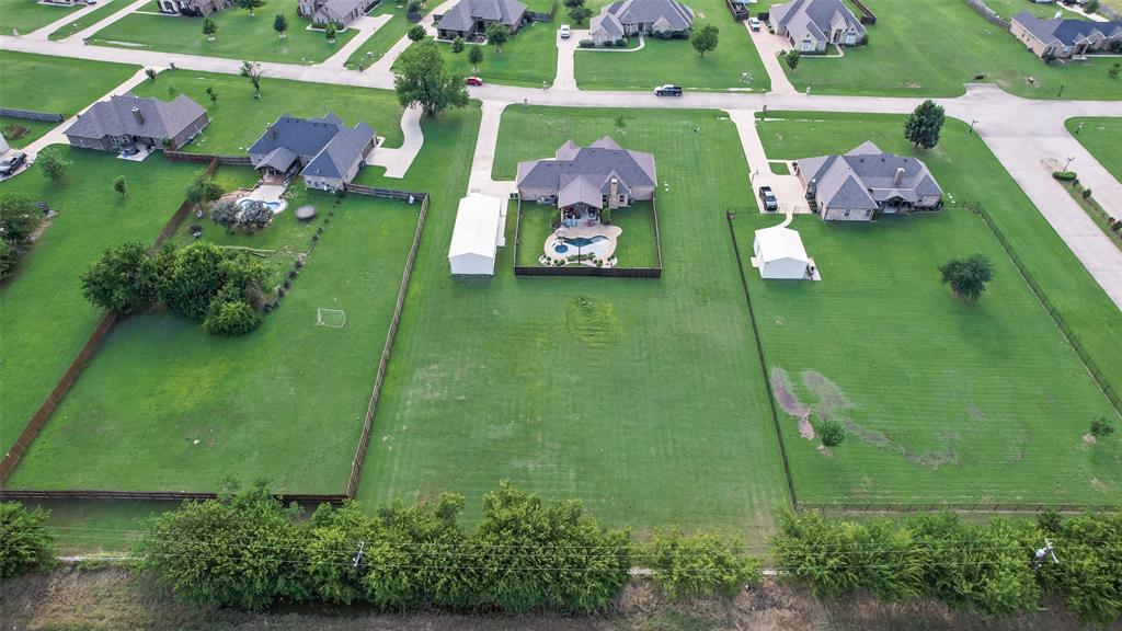 1132 Chartres Street Kaufman, TX 75142 - Photo 24 of 25 Expansive property featuring a single-family residence with a dark shingle roof, a curving driveway, and an outdoor swimming pool