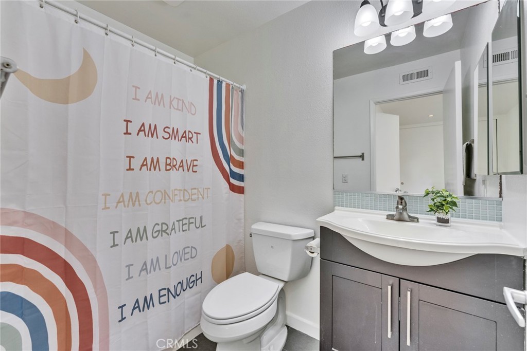 5 Hartford, Unit 36 Irvine, CA 92604 - Photo 17 of 37 a bathroom with a sink a mirror a toilet and a shower curtain