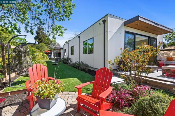a view of a house with backyard sitting area and garden