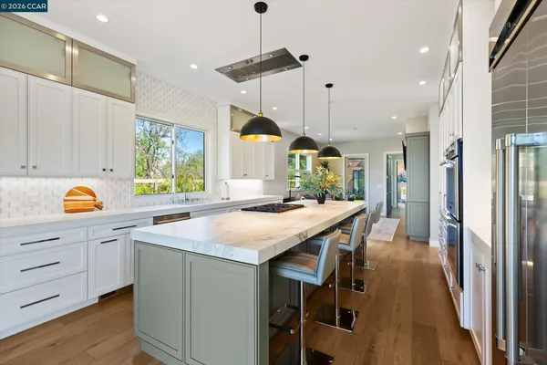 a kitchen with a refrigerator a sink and wooden floor
