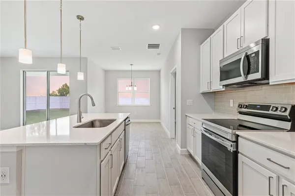 a kitchen with stainless steel appliances granite countertop a sink a stove and a wooden floors