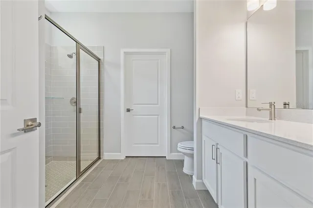 a bathroom with a double vanity sink toilet and shower