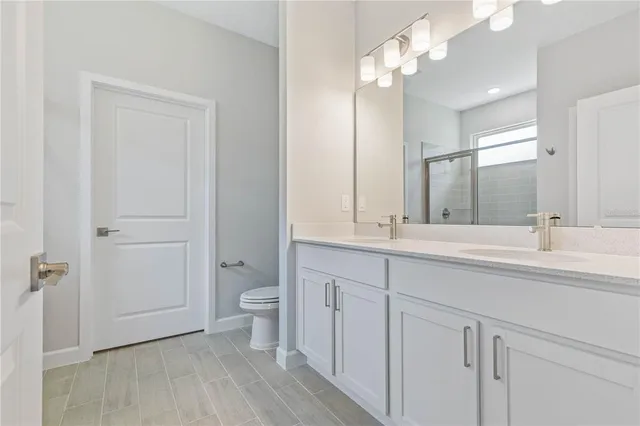 a bathroom with a double vanity sink and a toilet
