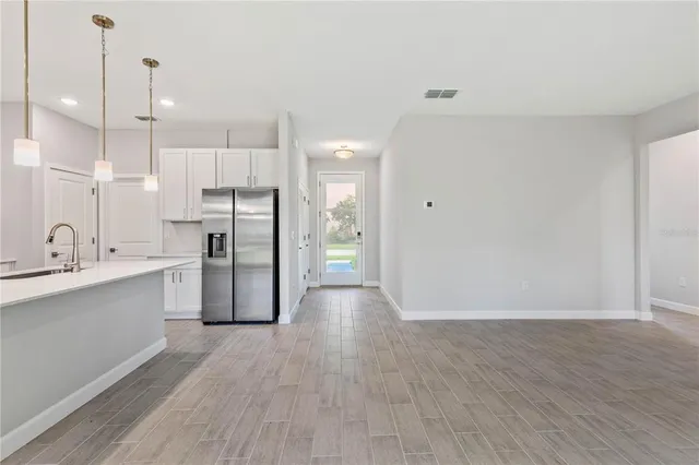 a view of a kitchen with wooden floor and a sink