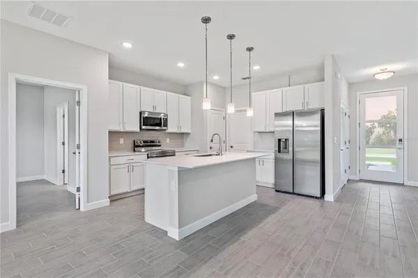 a kitchen with stainless steel appliances a refrigerator sink and microwave