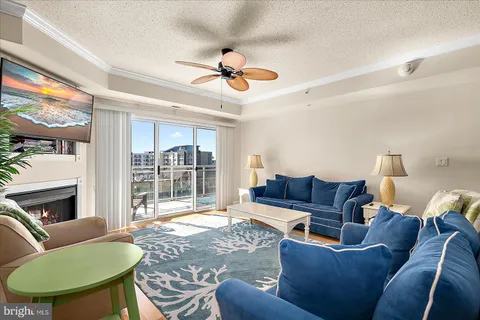 a living room with furniture a fireplace and a large window