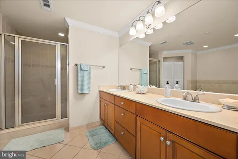a bathroom with a double vanity sink mirror and shower