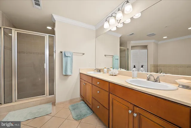 a bathroom with a double vanity sink mirror and shower
