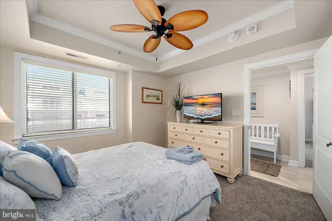 a bedroom with a bed and furniture with a flat tv screen