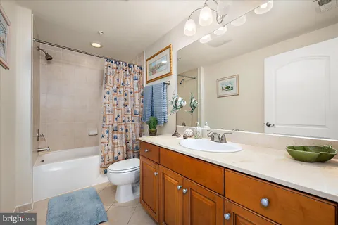 a bathroom with a double vanity sink toilet mirror and shower