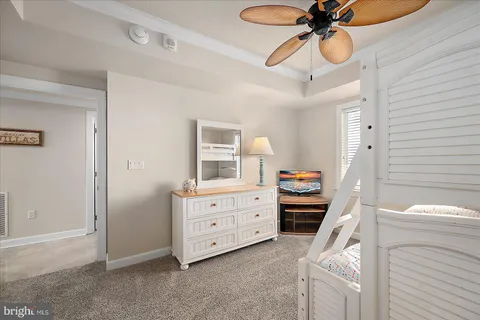 a bedroom with a baby bed dresser and a window