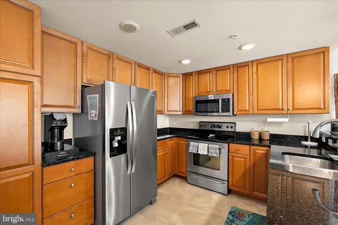 a kitchen with stainless steel appliances granite countertop a refrigerator stove and sink