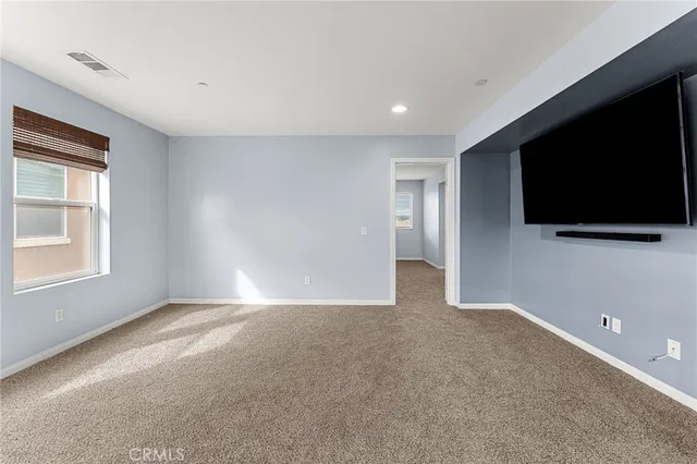 a view of an empty room with a flat screen tv and a window