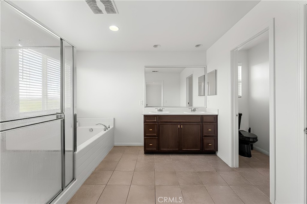 136 Yosemite Avenue Perris, CA 92570 - Photo 19 of 31 a spacious bathroom with a tub sink and mirror