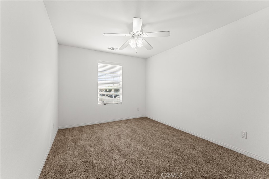 136 Yosemite Avenue Perris, CA 92570 - Photo 23 of 31 an empty room with a window and a fan