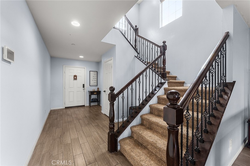 136 Yosemite Avenue Perris, CA 92570 - Photo 10 of 31 a view of staircase with wooden floor and white walls
