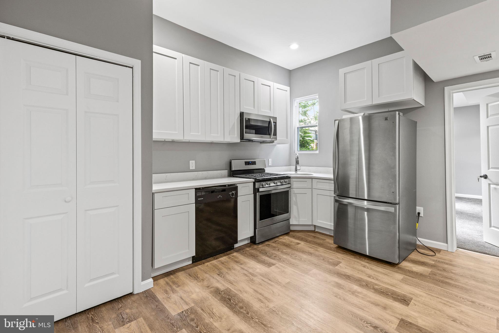 1809 West Lombard Street Baltimore, MD 21223 - Photo 5 of 36 a kitchen with a refrigerator stove and microwave