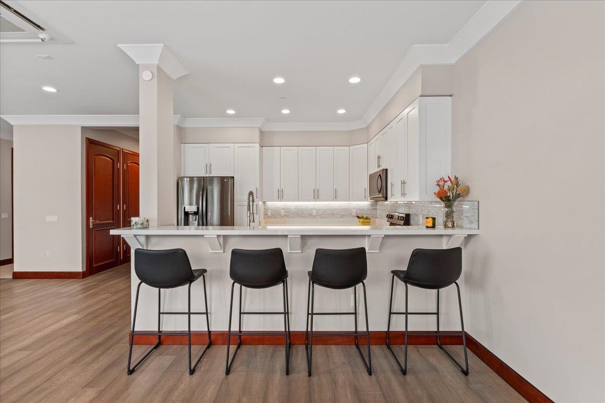 2757 South Kihei Road, Unit 801 Kihei, HI 96753 - Photo 11 of 41 a kitchen with a dining table chairs and wooden floor