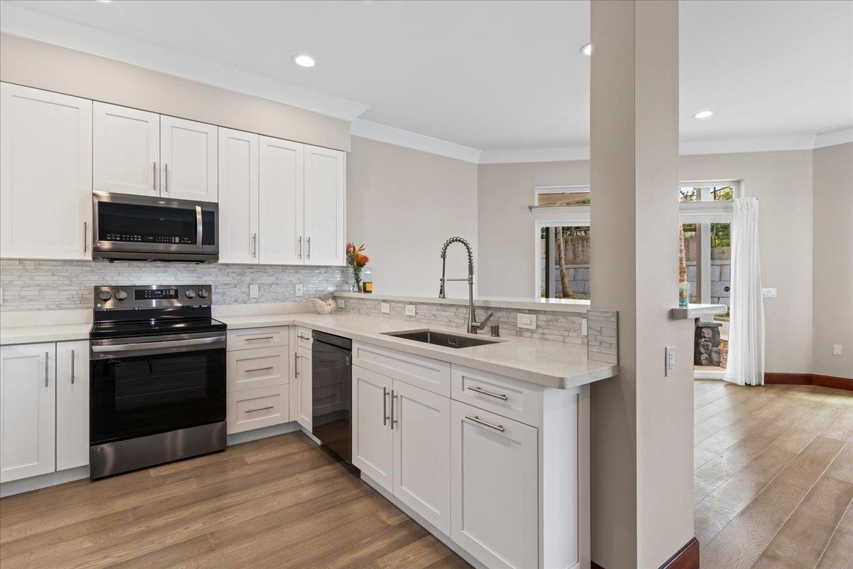 2757 South Kihei Road, Unit 801 Kihei, HI 96753 - Photo 15 of 41 a kitchen with stainless steel appliances granite countertop a stove top oven a sink dishwasher and a refrigerator with wooden floor