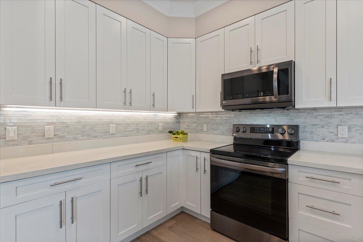 2757 South Kihei Road, Unit 801 Kihei, HI 96753 - Photo 16 of 41 a kitchen with white cabinets and black appliances