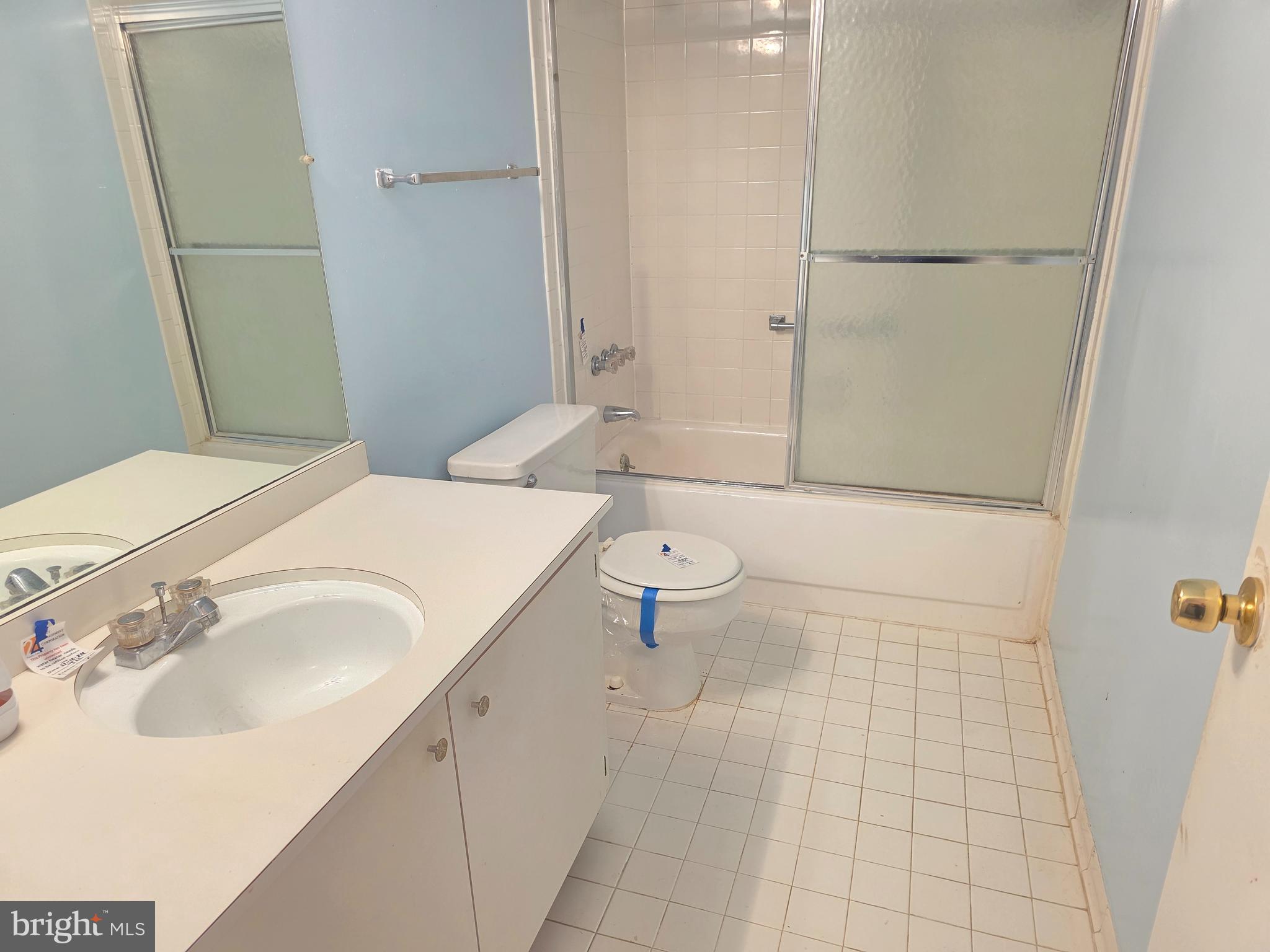 6317 Park Heights Avenue, Unit 103 Baltimore, MD 21215 - Photo 6 of 10 a bathroom with a sink a toilet and shower