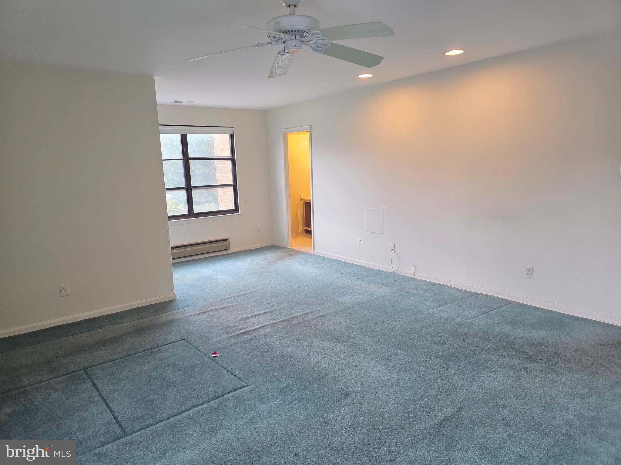 6317 Park Heights Avenue, Unit 103 Baltimore, MD 21215 - Photo 7 of 10 an empty room with windows and fan