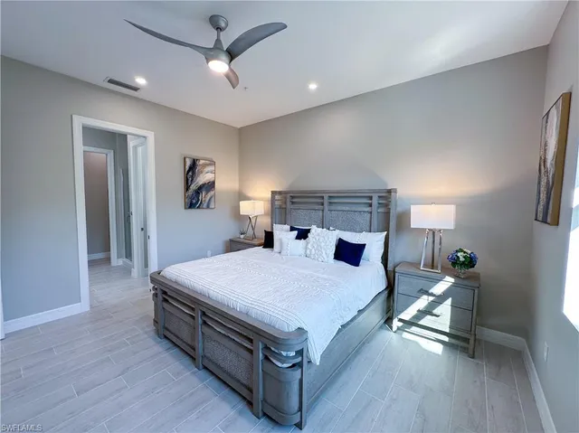 a spacious bedroom with a bed and a chandelier